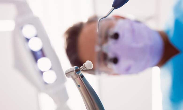 dentista che tiene gli strumenti dentali